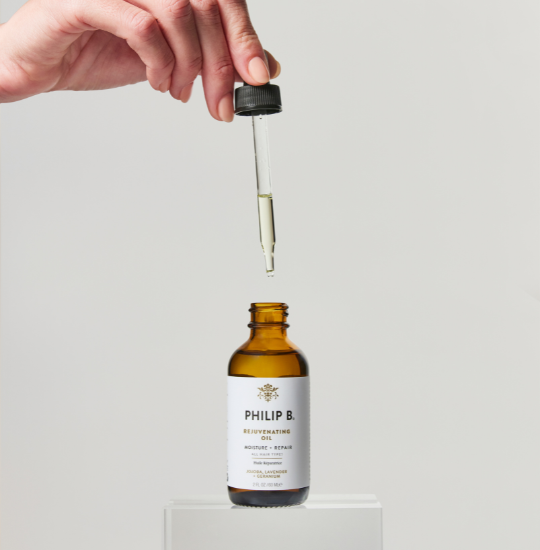 hand-using-dropper-to-philip-b-rejunevating-oil