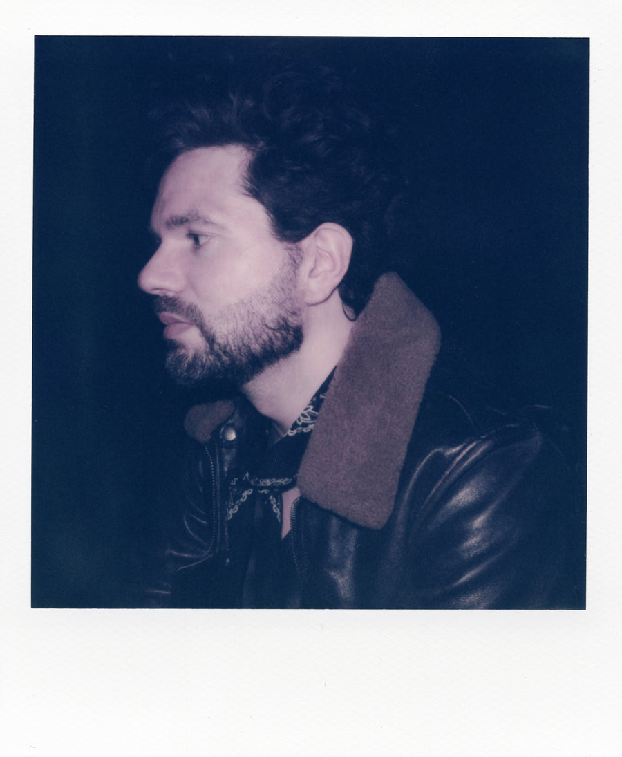 Man-wearing-a-leather-jacket-with-a-dark-background